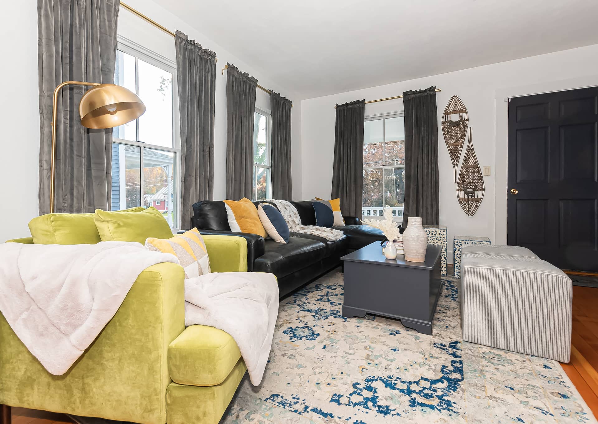 The living room with its green sofa and dark painted walls